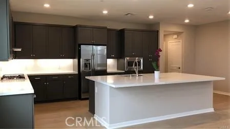 a large kitchen with stainless steel appliances a large counter top
