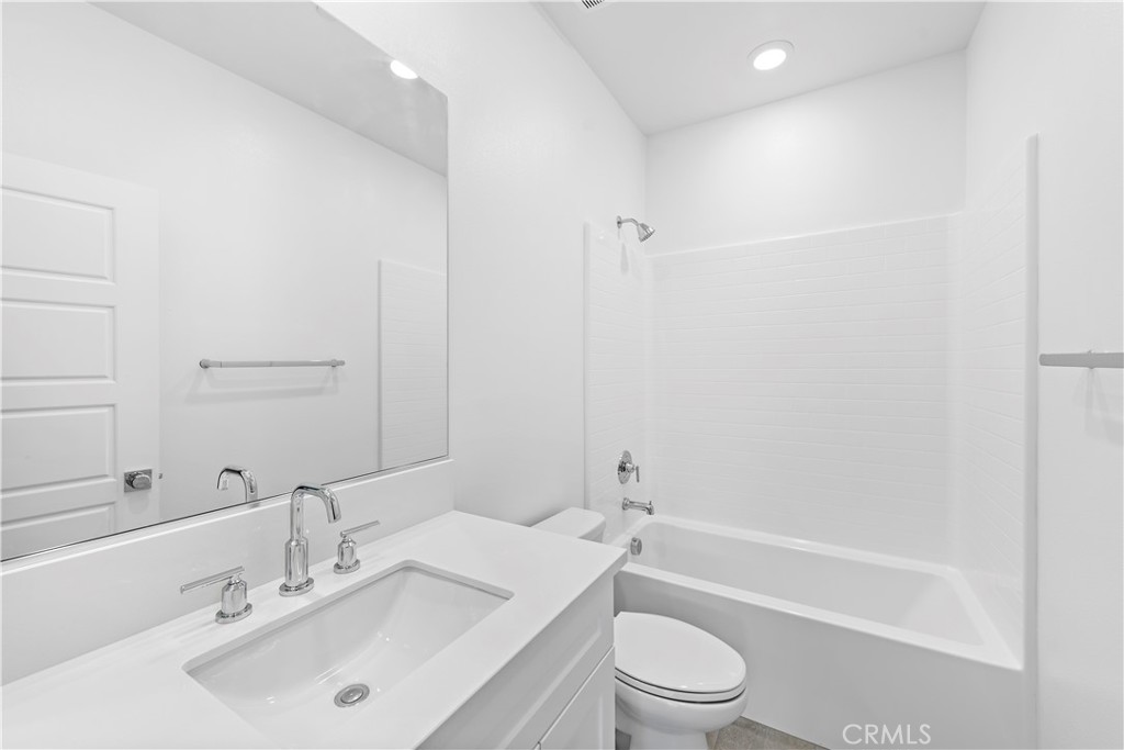 235 Carmona Lake Forest, CA 92630 - Photo 13 of 21 a bathroom with a toilet a sink a mirror and shower