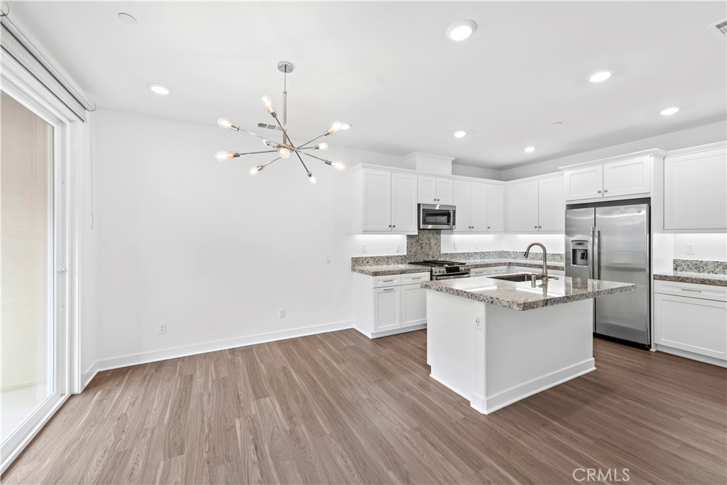 235 Carmona Lake Forest, CA 92630 - Photo 5 of 21 a kitchen with stainless steel appliances granite countertop a white cabinets and wooden floor