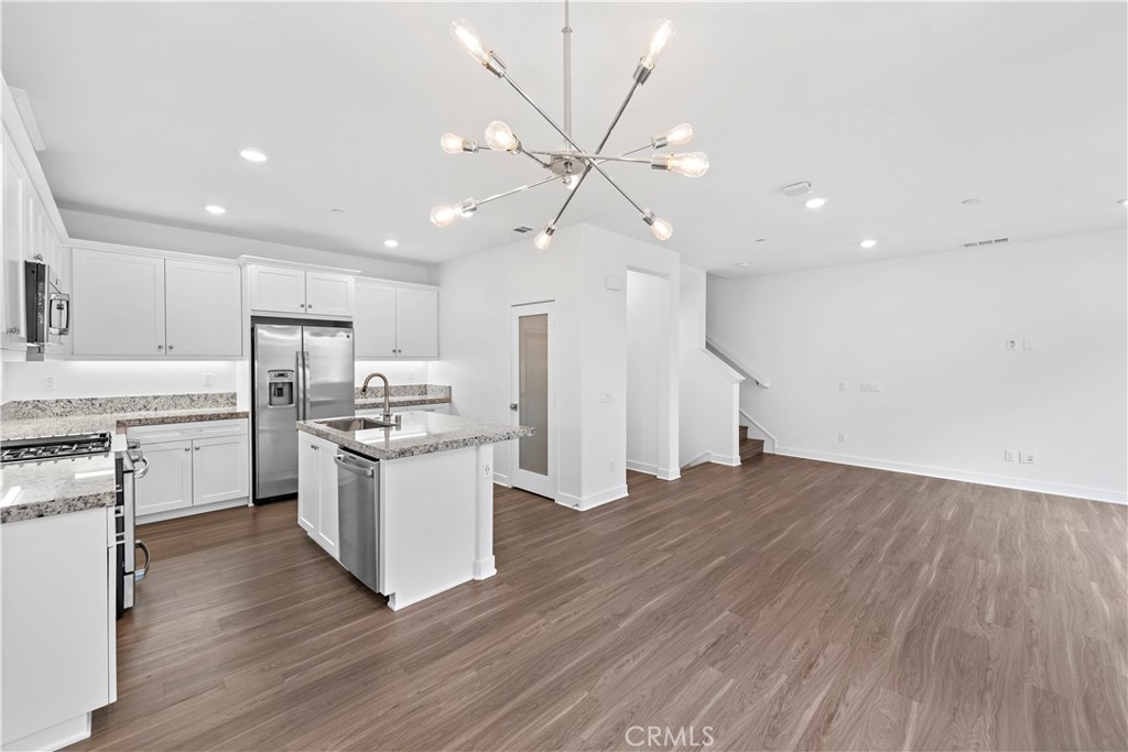 235 Carmona Lake Forest, CA 92630 - Photo 6 of 21 a kitchen with a refrigerator and white cabinets