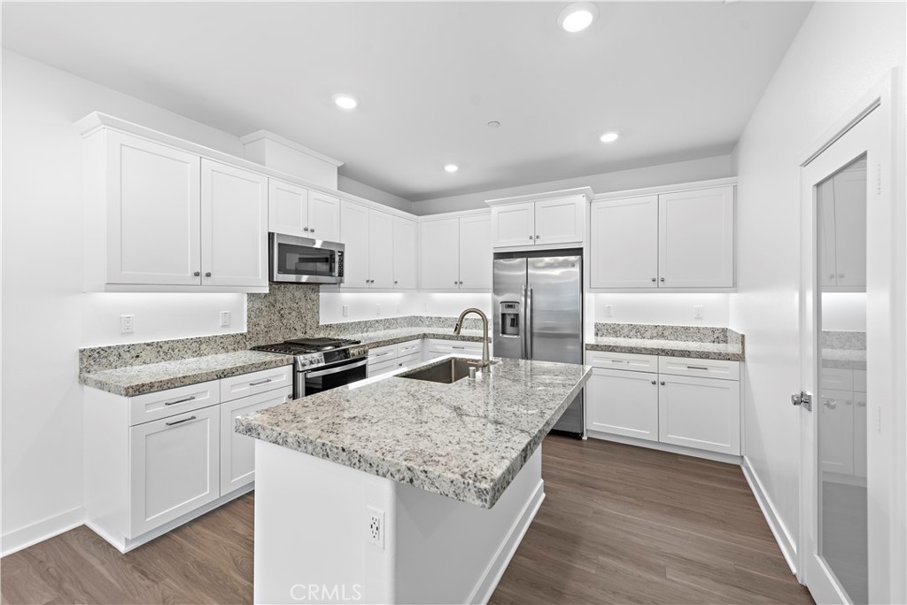 235 Carmona Lake Forest, CA 92630 - Photo 7 of 21 a kitchen with refrigerator a stove a sink and a microwave