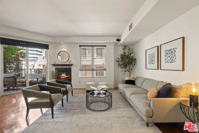 a living room with furniture a fireplace and a large window