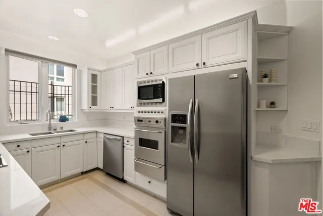 a kitchen with white cabinets and stainless steel appliances