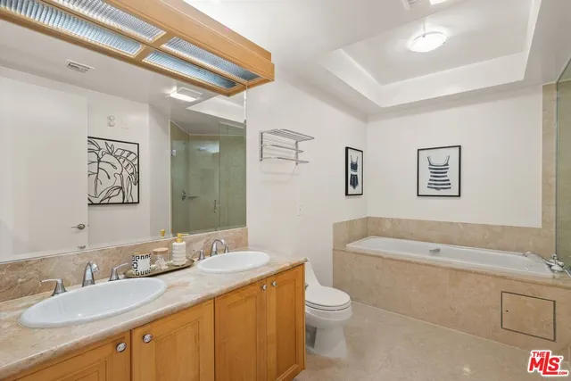 a bathroom with a granite countertop sink mirror vanity bathtub and toilet