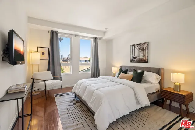 a bedroom with a bed wooden floor and lamp