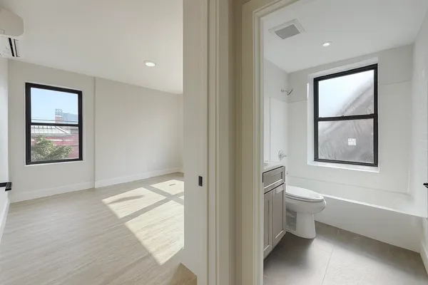 a bathroom with a toilet tub and a window