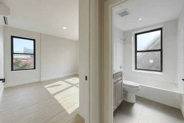 a bathroom with a toilet tub and a window