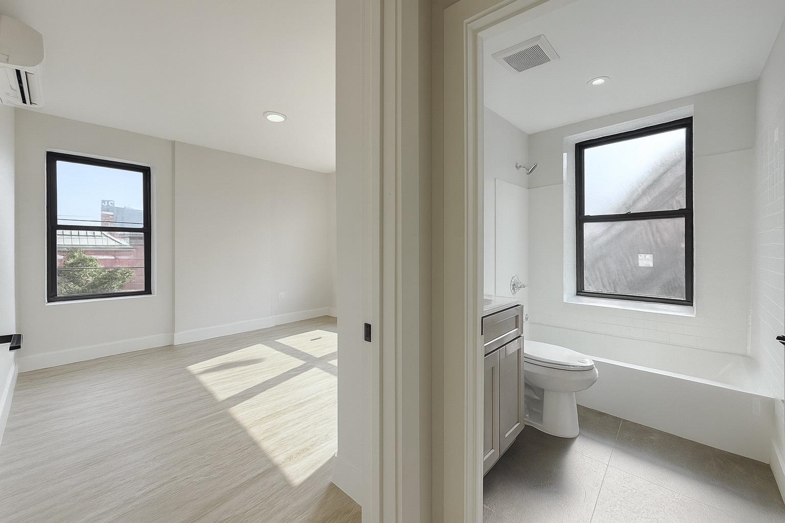 103 Bostwick Avenue, Unit 3A Jersey City, NJ 07305 - Photo 13 of 18 a bathroom with a toilet tub and a window
