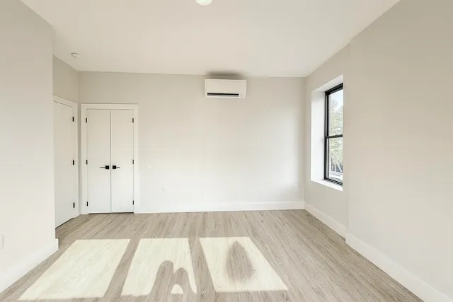a view of room with window and wooden floor