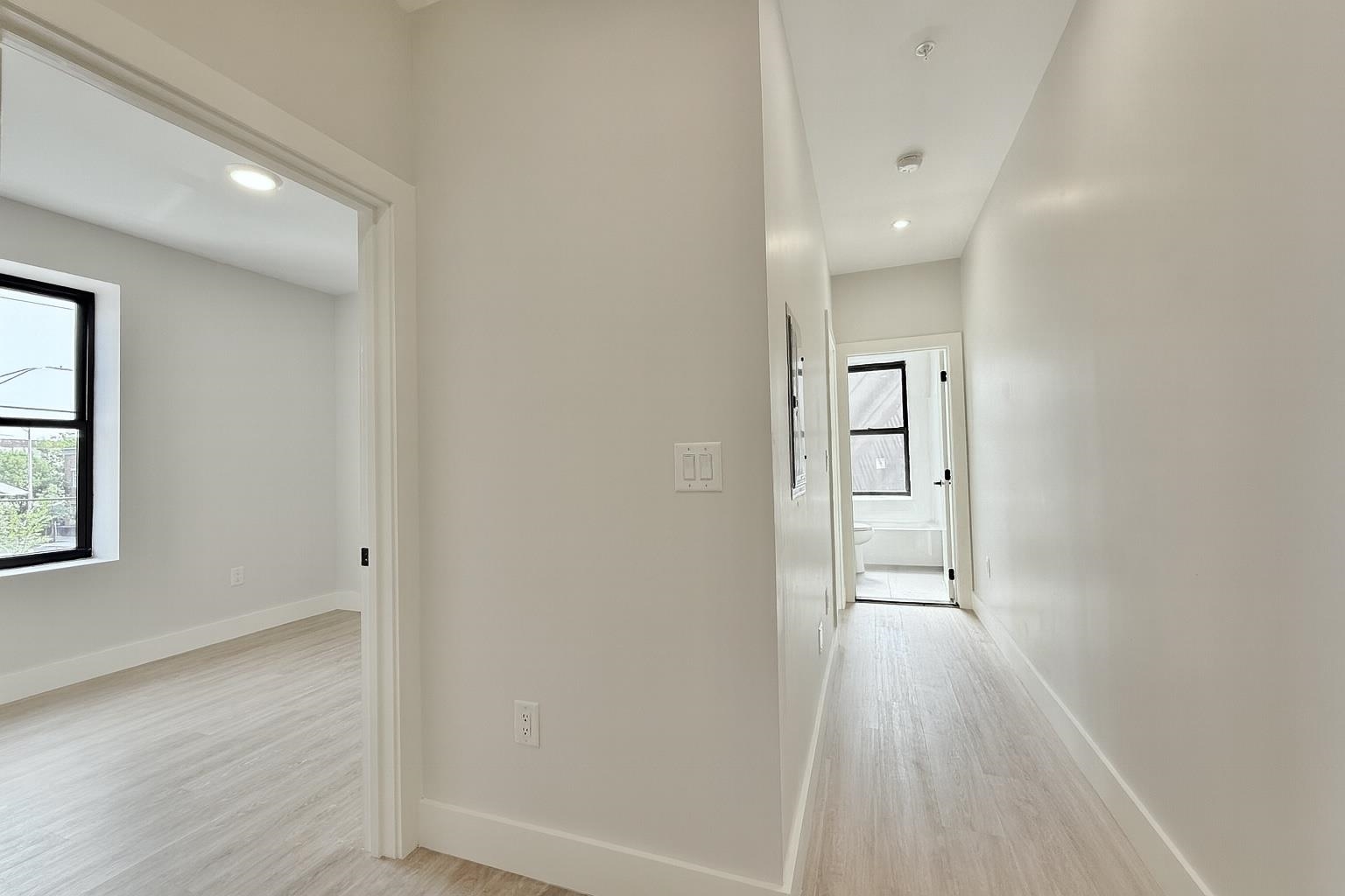 103 Bostwick Avenue, Unit 3A Jersey City, NJ 07305 - Photo 16 of 18 wooden floor in an empty room with a window
