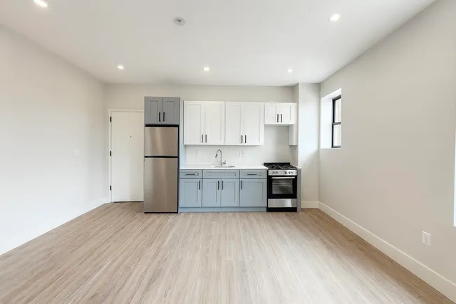 a kitchen with stainless steel appliances a refrigerator and a stove top oven