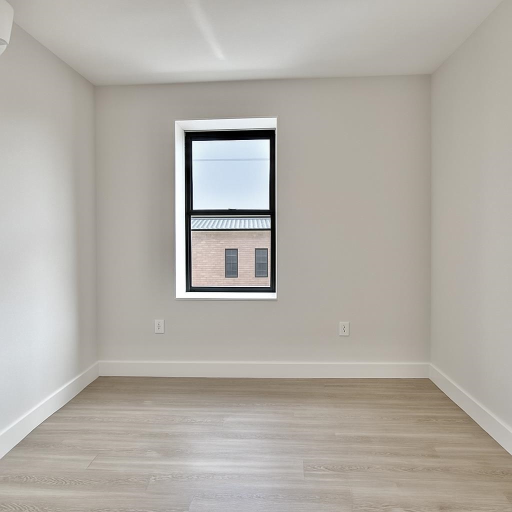 103 Bostwick Avenue, Unit 3A Jersey City, NJ 07305 - Photo 9 of 18 a view of a small space with wooden floor and a window