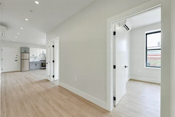 a view of empty room with wooden floor and windows