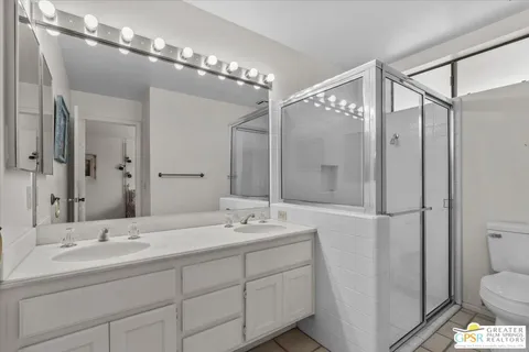 a bathroom with a double vanity sink mirror and toilet