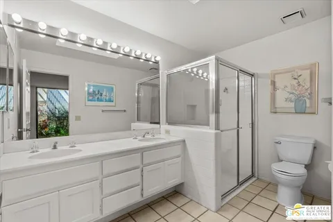 a spacious bathroom with a double vanity sink toilet and shower