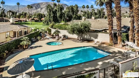a view of a swimming pool with outdoor seating and plants