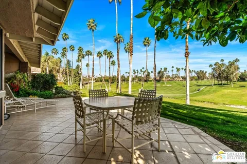 a view of a chairs and table in patio with a lake view