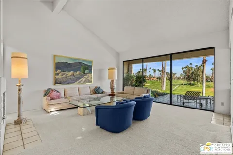 a living room with furniture and a floor to ceiling window
