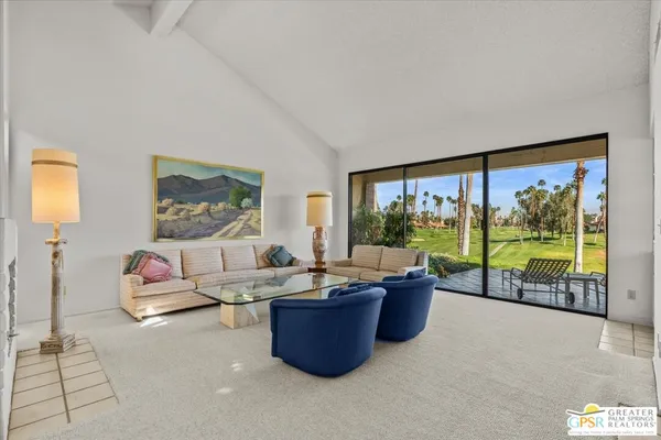 a living room with furniture and a floor to ceiling window
