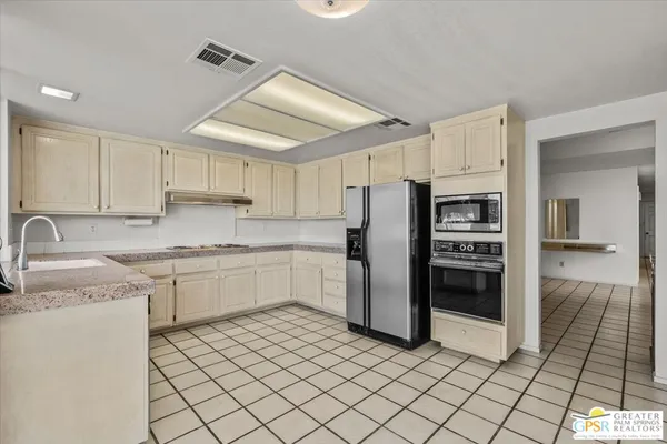 a kitchen with stainless steel appliances granite countertop a refrigerator and a sink