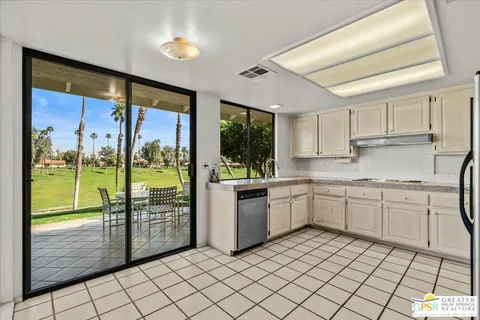a kitchen with a sink a counter top space and stainless steel appliances cabinets