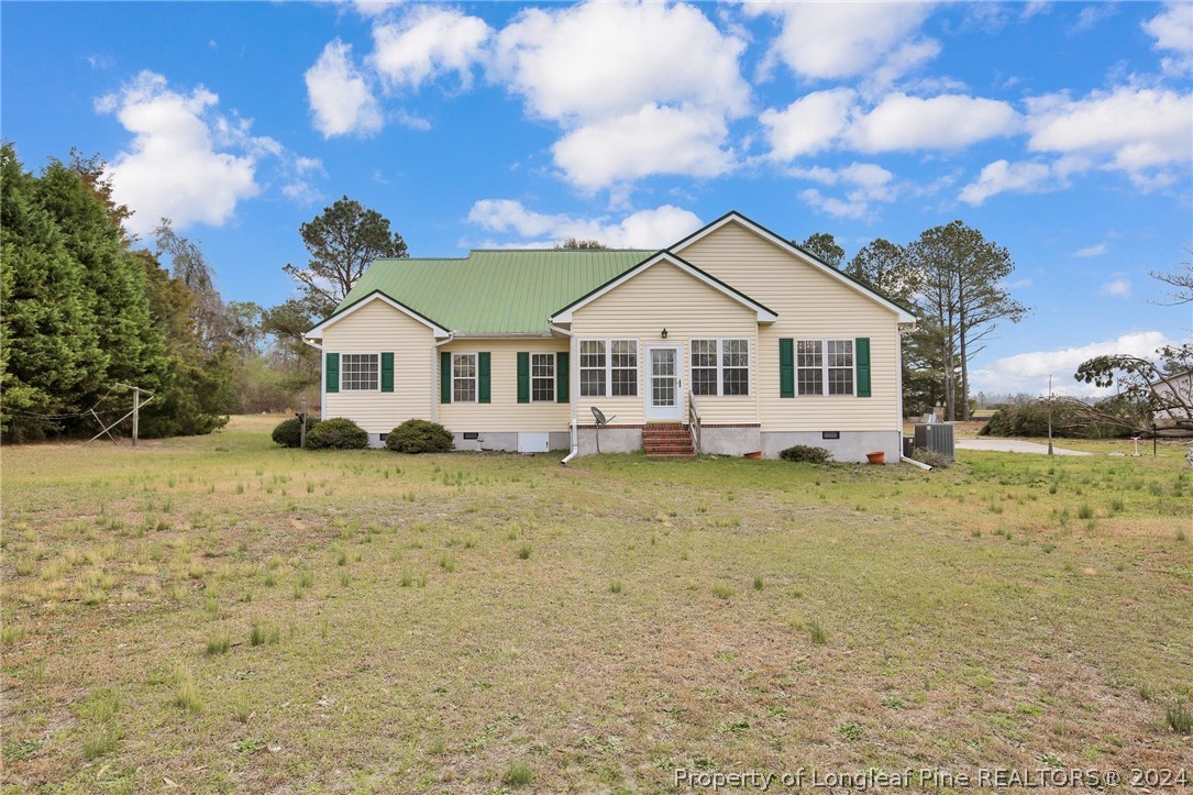 10703 Aberdeen Road Aberdeen, NC 28315 - Photo 2 of 33 a front view of a house with a garden and trees