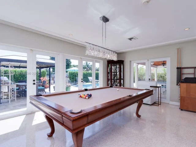 a room with pool table and windows