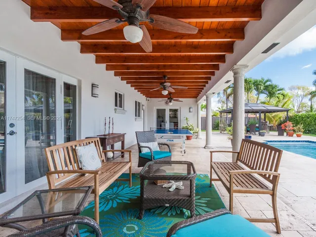 a view of a patio with table and chairs under an umbrella with a small yard