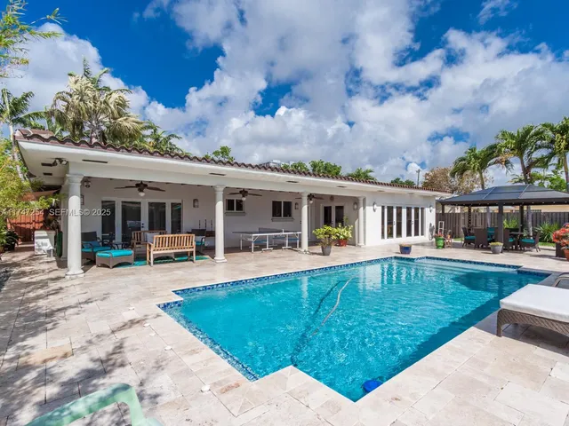 a view of a house with backyard sitting area and garden