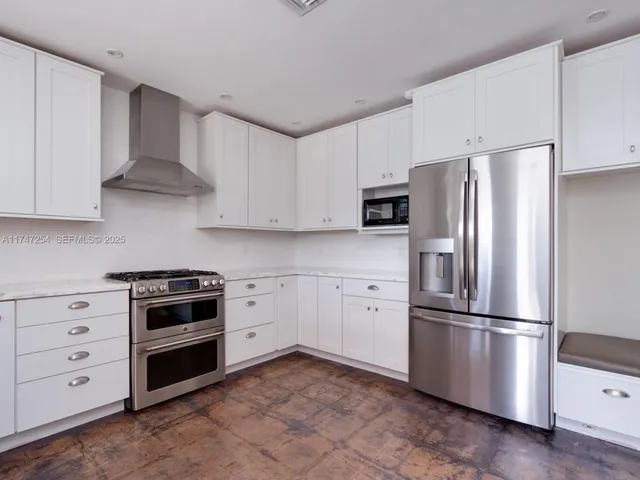 a kitchen with stainless steel appliances white cabinets white stove a refrigerator and a microwave