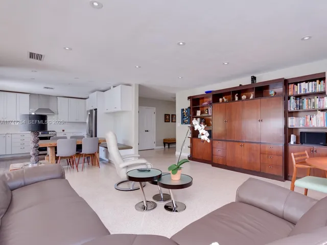 a living room with furniture kitchen view and a table