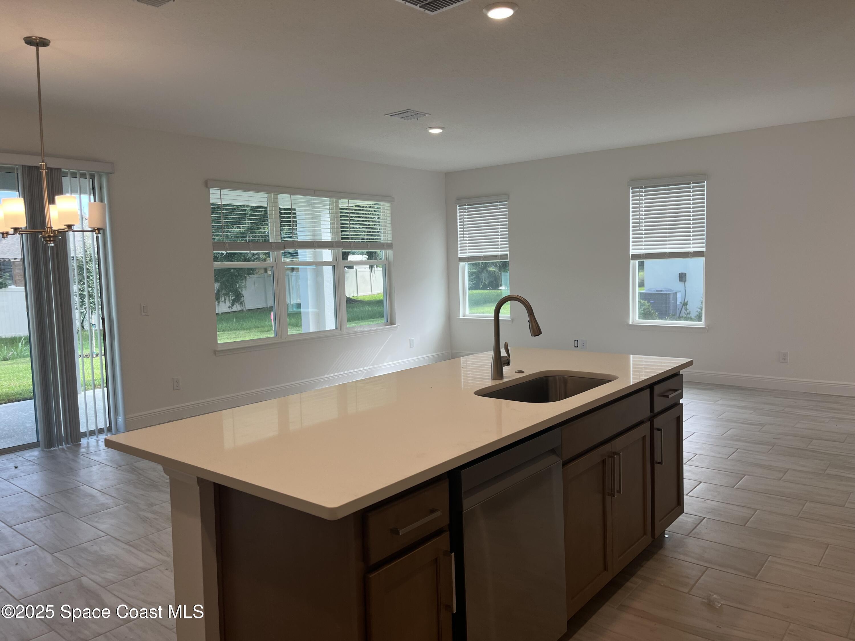 2082 Killian Drive Palm Bay, FL 32905 - Photo 4 of 9 a kitchen with a sink a counter and cabinets
