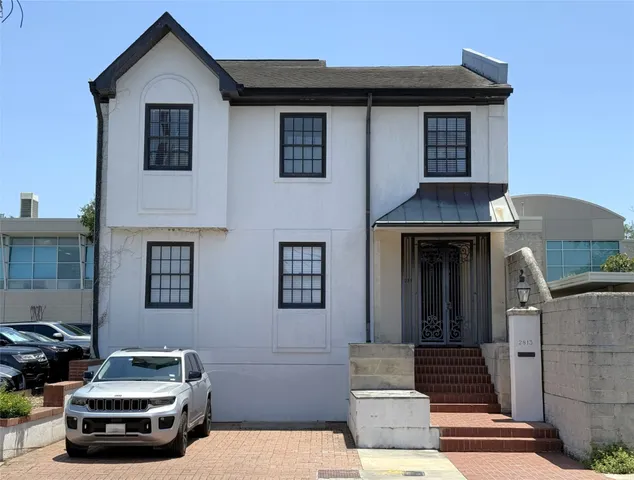 a car parked in front of a white house