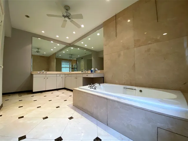 a bathroom with a tub sink and mirror