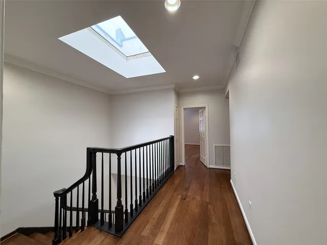 an empty room with wooden floor and natural light