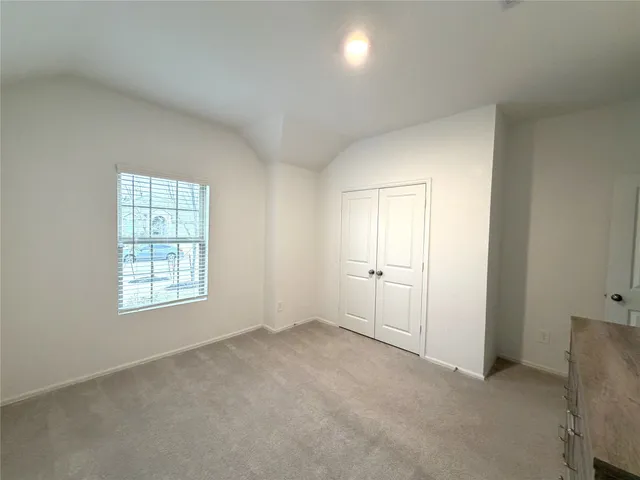 an empty room with windows and closet