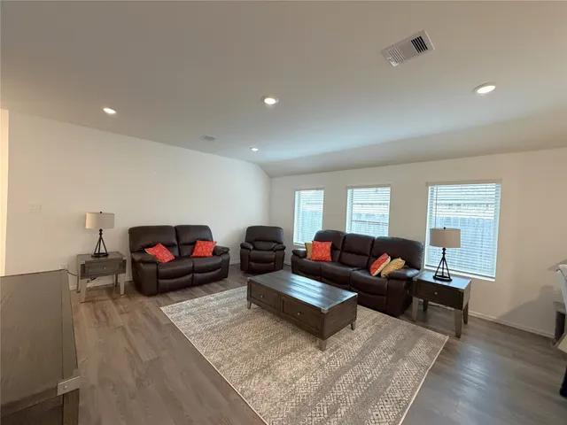 a living room with furniture and wooden floor