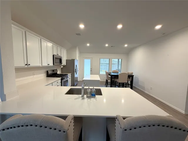 a large white kitchen with a large window