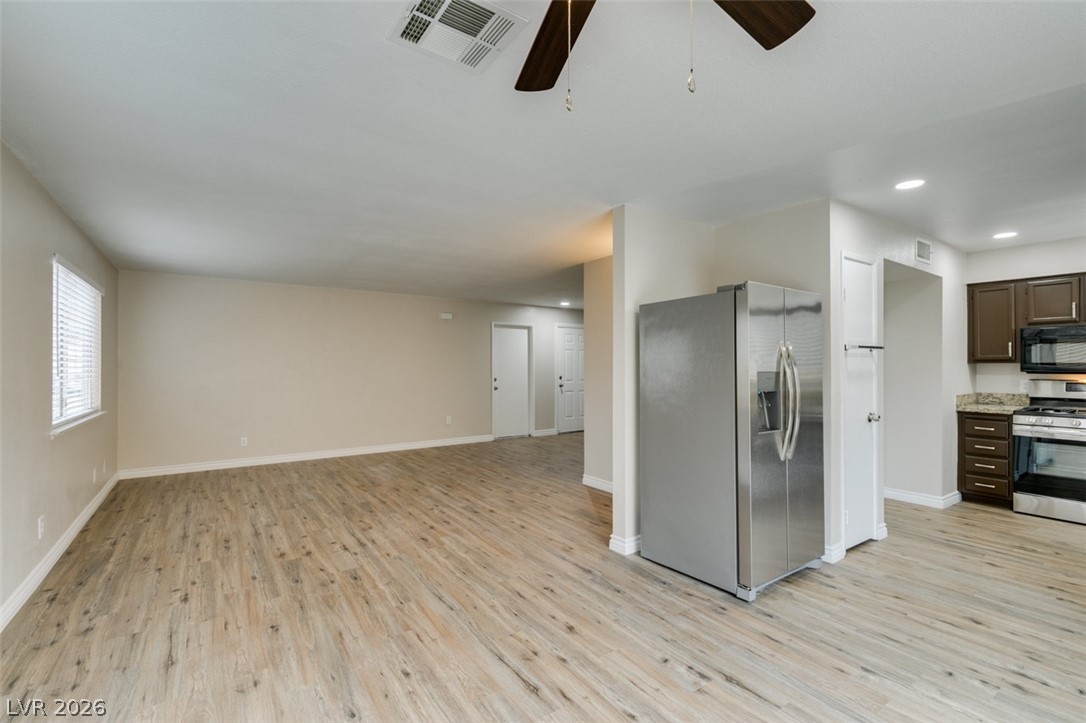 905 Scarlet Ridge Drive Las Vegas, NV 89128 - Photo 39 of 39 Kitchen featuring stainless steel appliances, dark wood finish cabinetry, ceiling fan, light wood-type flooring, and open floor plan