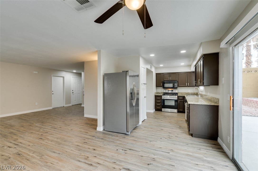 905 Scarlet Ridge Drive Las Vegas, NV 89128 - Photo 16 of 39 Kitchen featuring stainless steel appliances, dark wood finish cabinets, ceiling fan, light wood-style flooring, and recessed lighting
