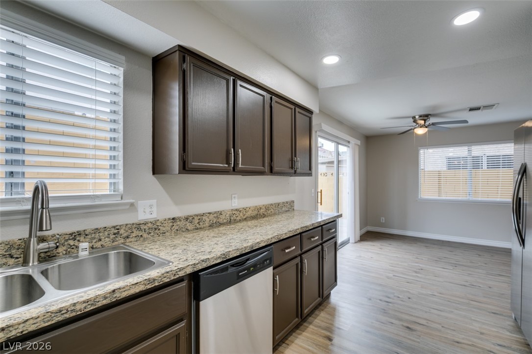 905 Scarlet Ridge Drive Las Vegas, NV 89128 - Photo 22 of 39 Kitchen featuring dark wood finish cabinets, stainless steel appliances, ceiling fan, light wood-type flooring, and recessed lighting