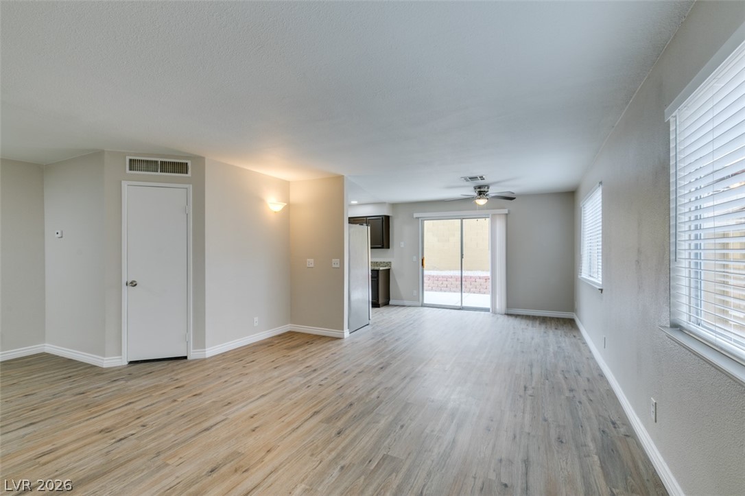 905 Scarlet Ridge Drive Las Vegas, NV 89128 - Photo 7 of 39 Unfurnished living room with light wood-type flooring and a ceiling fan