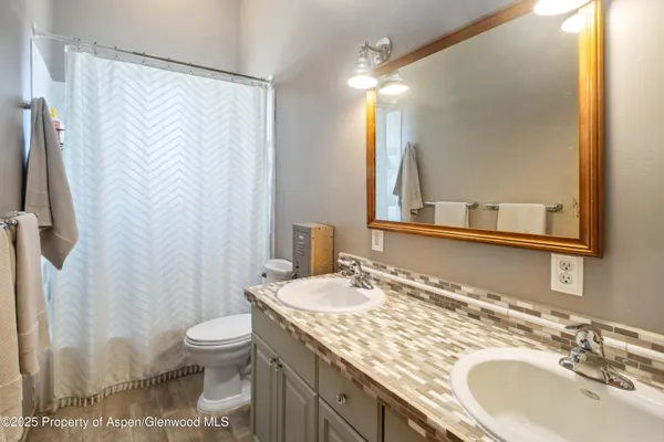 a bathroom with a granite countertop sink toilet and shower