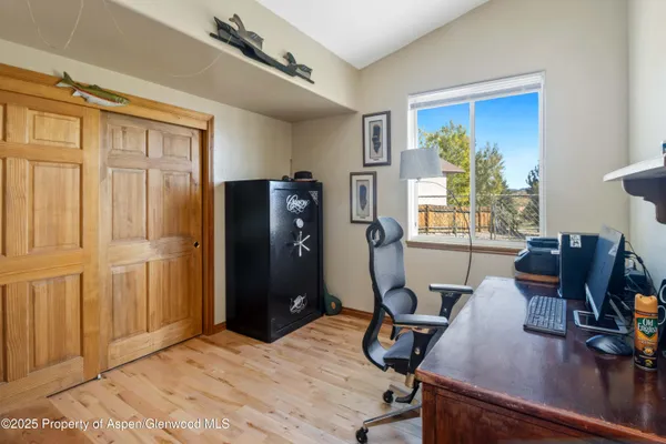 a view of a workspace with furniture and a window