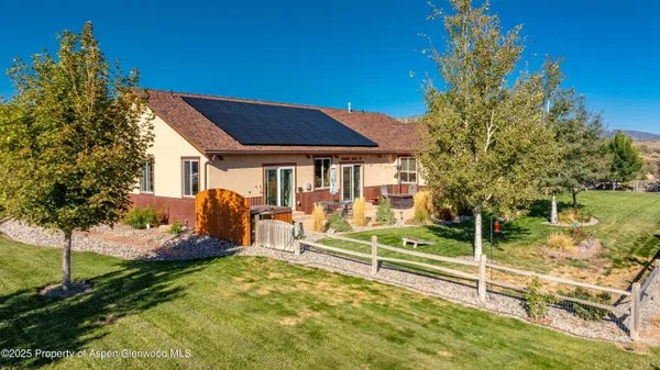 a view of a house with backyard and sitting area