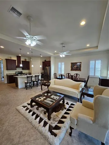 a living room with lots of furniture and kitchen view