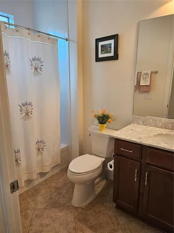 a bathroom with a granite countertop toilet a sink and a shower