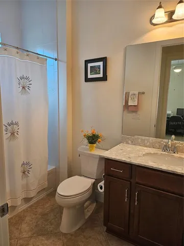 a bathroom with a granite countertop toilet sink and mirror