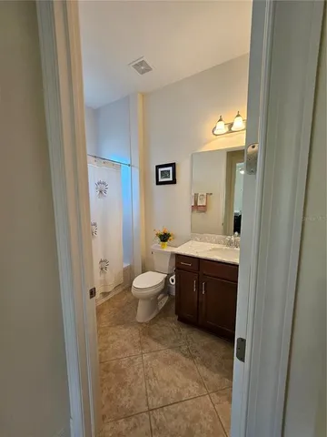 a spacious bathroom with a sink a toilet and a mirror