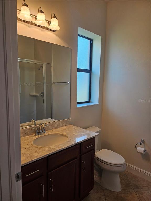 1283 Manado Drive Naples, FL 34113 - Photo 19 of 48 a bathroom with a granite countertop toilet sink and mirror